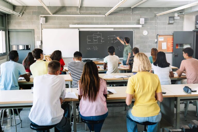 High School Teacher explaining electronics circuits To Pupils learning In Technology course